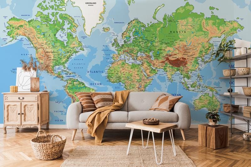 Vintage world map mural wallpaper featuring green and blue design, grey sofa, light wooden flooring.