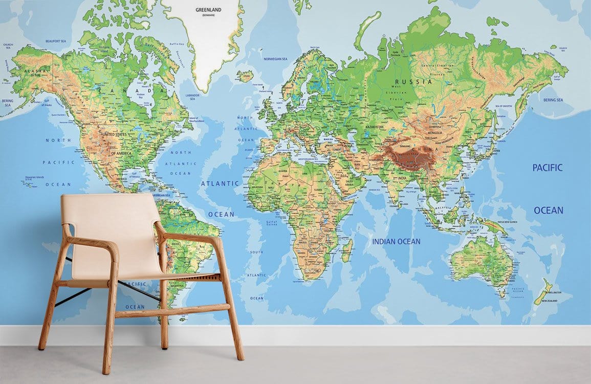 Vintage world map mural wallpaper, green-blue, with wooden chair, grey flooring, modern room setting.