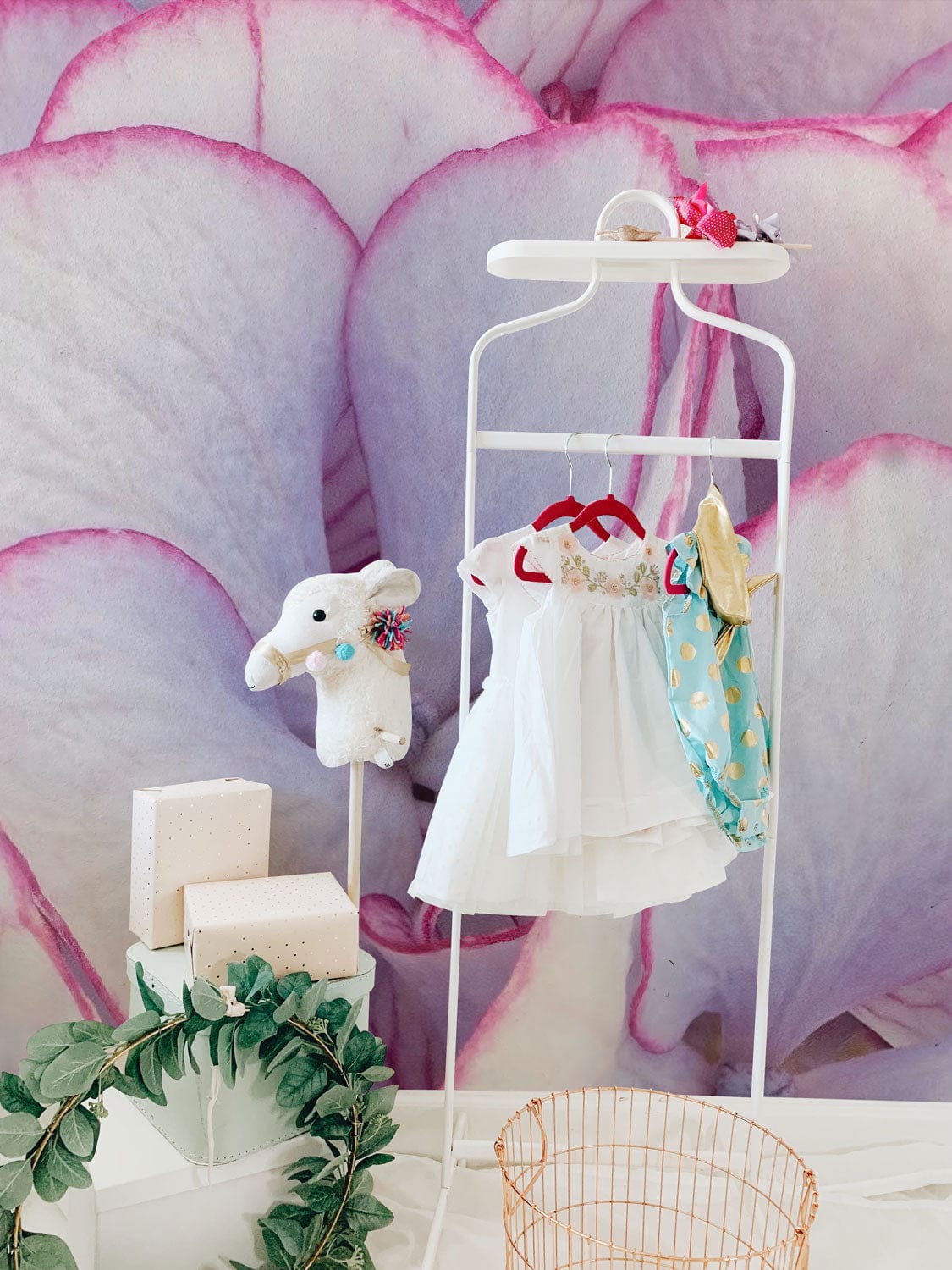 Elegant Hydrangea Blooms Wallpaper with children's clothes, soft pink petals backdrop, and decorative plush toy.