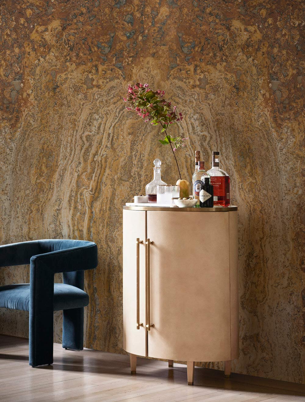 Elegant marble-patterned wallpaper with plush blue chair and beige cabinet; perfect for modern living rooms.