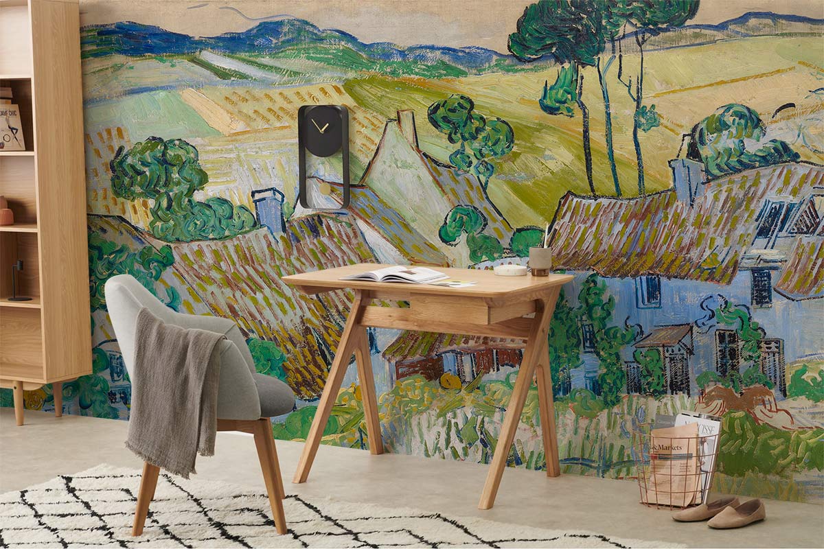 Charming Countryside Cottages mural wallpaper; rustic landscape. Green tones complement wood desk and grey chair.
