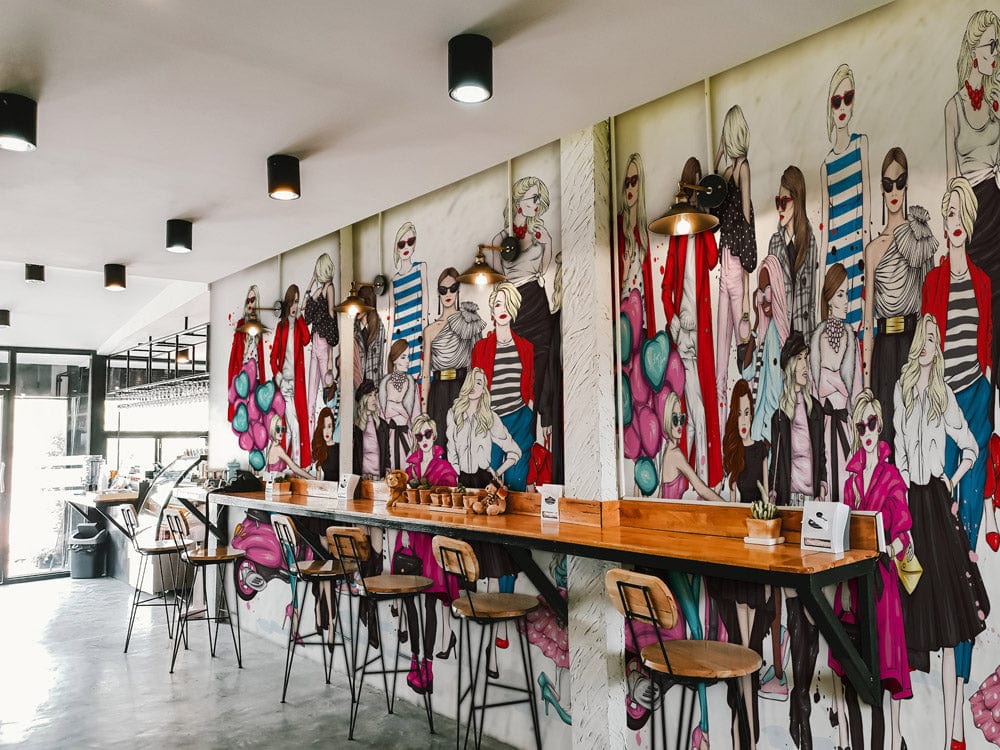 Chic Fashionista Pink & Red Illustration Mural Wallpaper in trendy cafe with bar stools and wooden counter.
