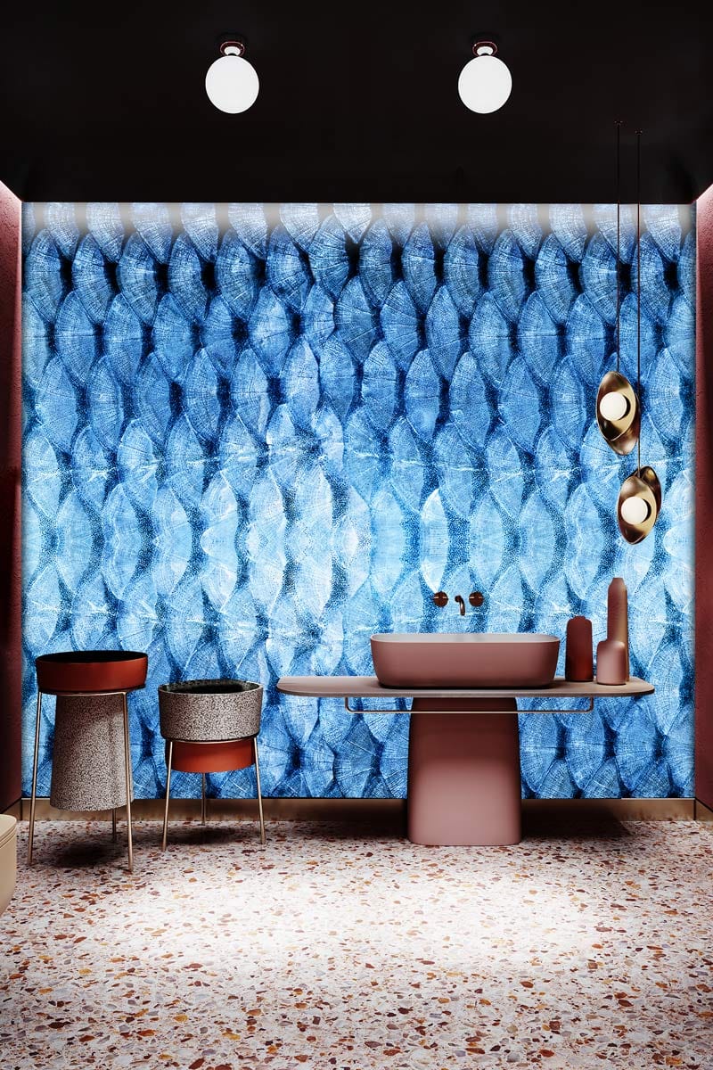 Blue geometric mural wallpaper in modern room, featuring terrazzo flooring, elegant chairs, and pendant lights.