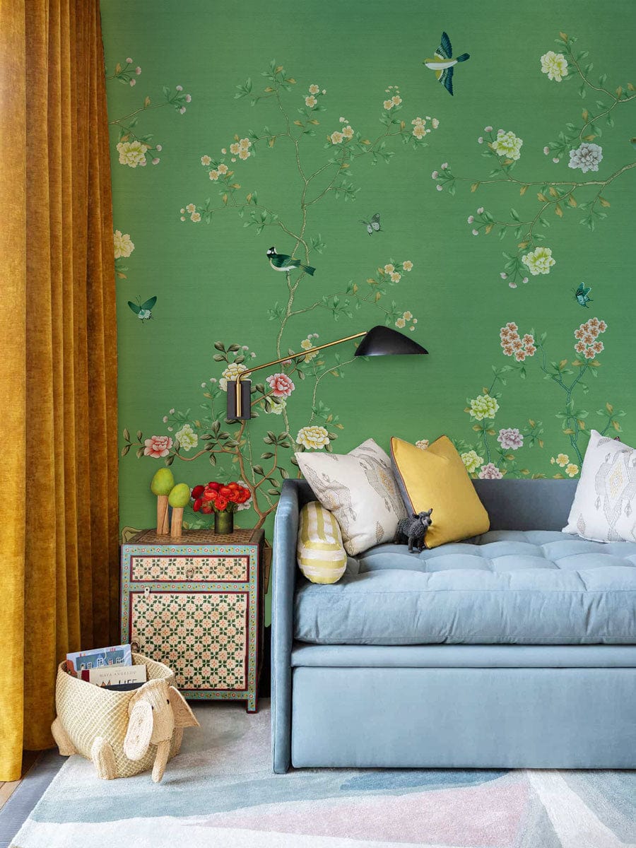 Elegant Green Floral Chinoiserie Wallpaper with birds, blue sofa, patterned side table, yellow curtains.