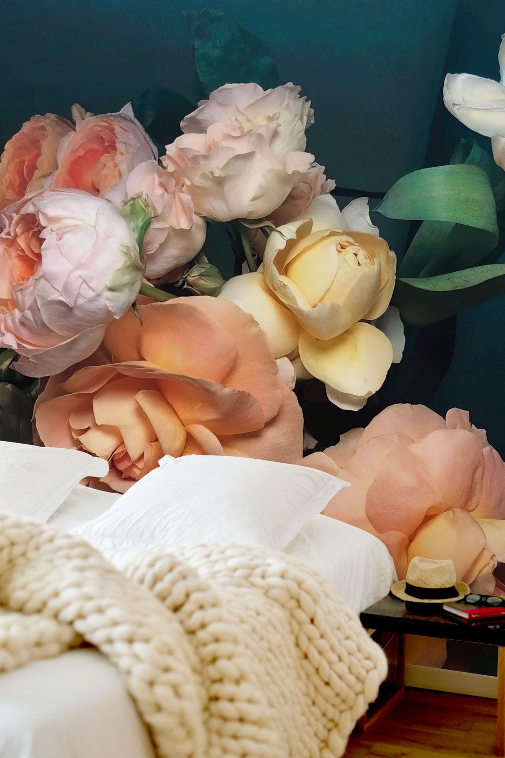 Elegant vintage floral wallpaper in soft pastels in a bedroom with white bedding and wood flooring.