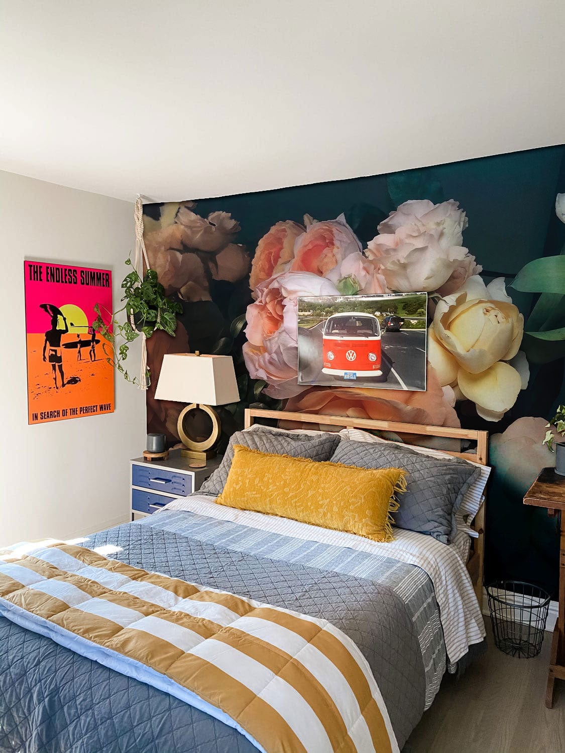 Bedroom with floral wallpaper, featuring colourful bed linens and a retro wall art.