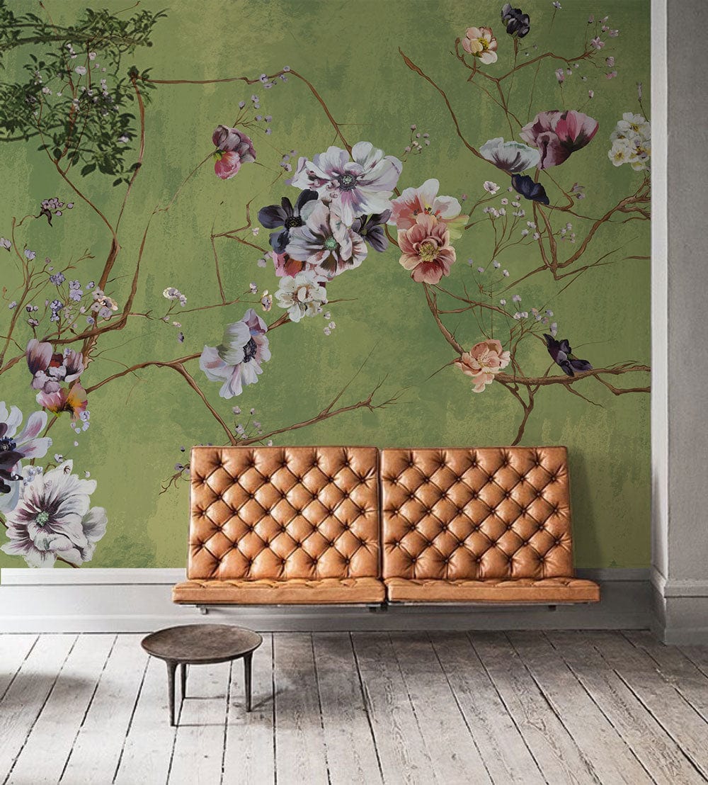 Elegant green floral mural wallpaper, tan tufted sofa, wooden flooring, cosy living room setting.