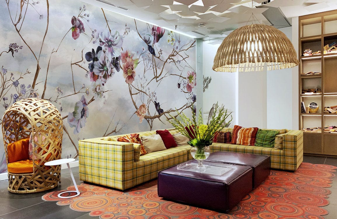 Living room with Serene Sky Floral Branches Mural Wallpaper, plaid sofa, rattan chair, pendant lamp.