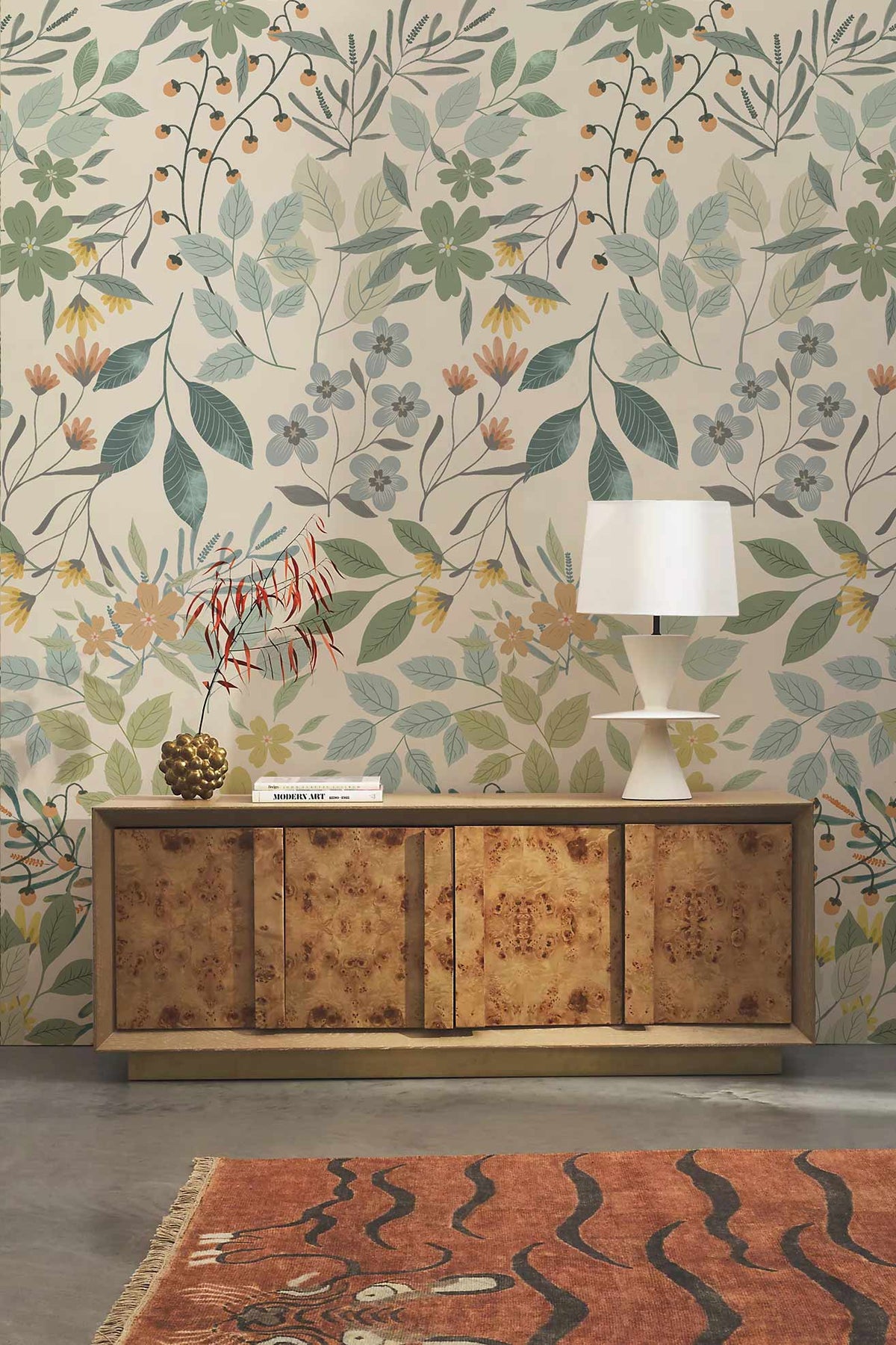 Vintage botanical floral wallpaper in soft green, wood sideboard, concrete flooring, earthy rug, white lamp.