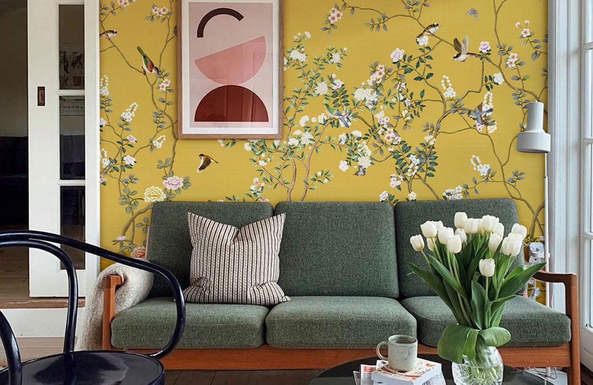 Golden Botanical Garden Mural Wallpaper features elegant floral and bird design with green sofa, wooden flooring.