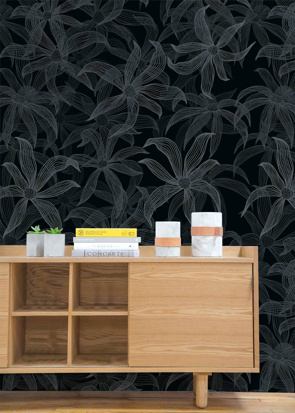 Elegant dark floral wallpaper with charcoal leaves, light wood cabinet, in contemporary living room setting.