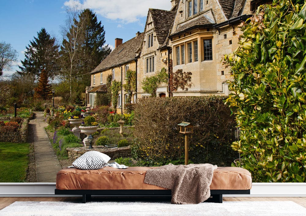 Charming Cotswold Cottage mural, tan sofa, soft rug, English countryside theme, green wall accents.