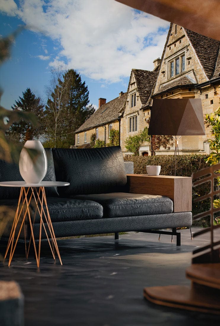Cosy living room with green Cotswold cottage mural, black sofa, modern side table, stylish lamp.