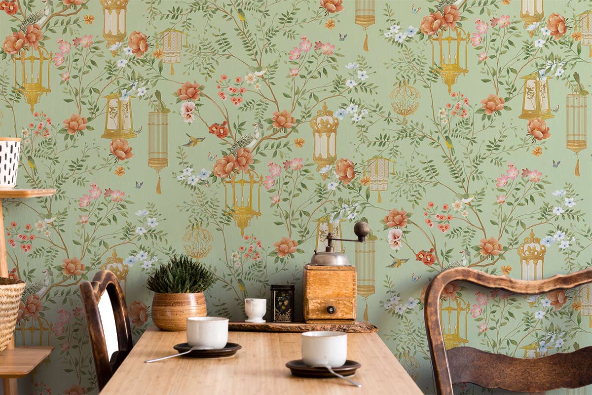 Vintage Oriental floral wallpaper with soft green backdrop, vintage-style wooden chairs, and dining table setting.