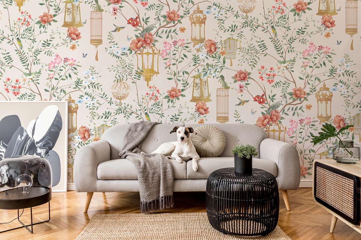 Elegant floral wallpaper design with cream background; grey sofa, wooden flooring, black round table.