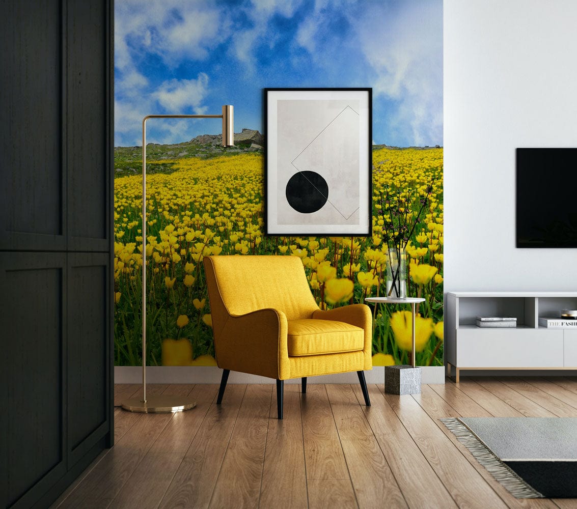 Yellow wildflower wallpaper in modern living room with mustard armchair and light wood flooring.
