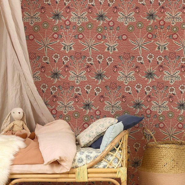 Vintage floral wallpaper in red and green, featuring a rattan bed with pastel bedding in bedroom.