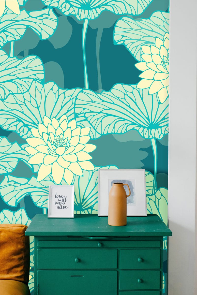 Teal and cream floral lotus wallpaper, with teal dresser and orange cushion, elegant room decor.