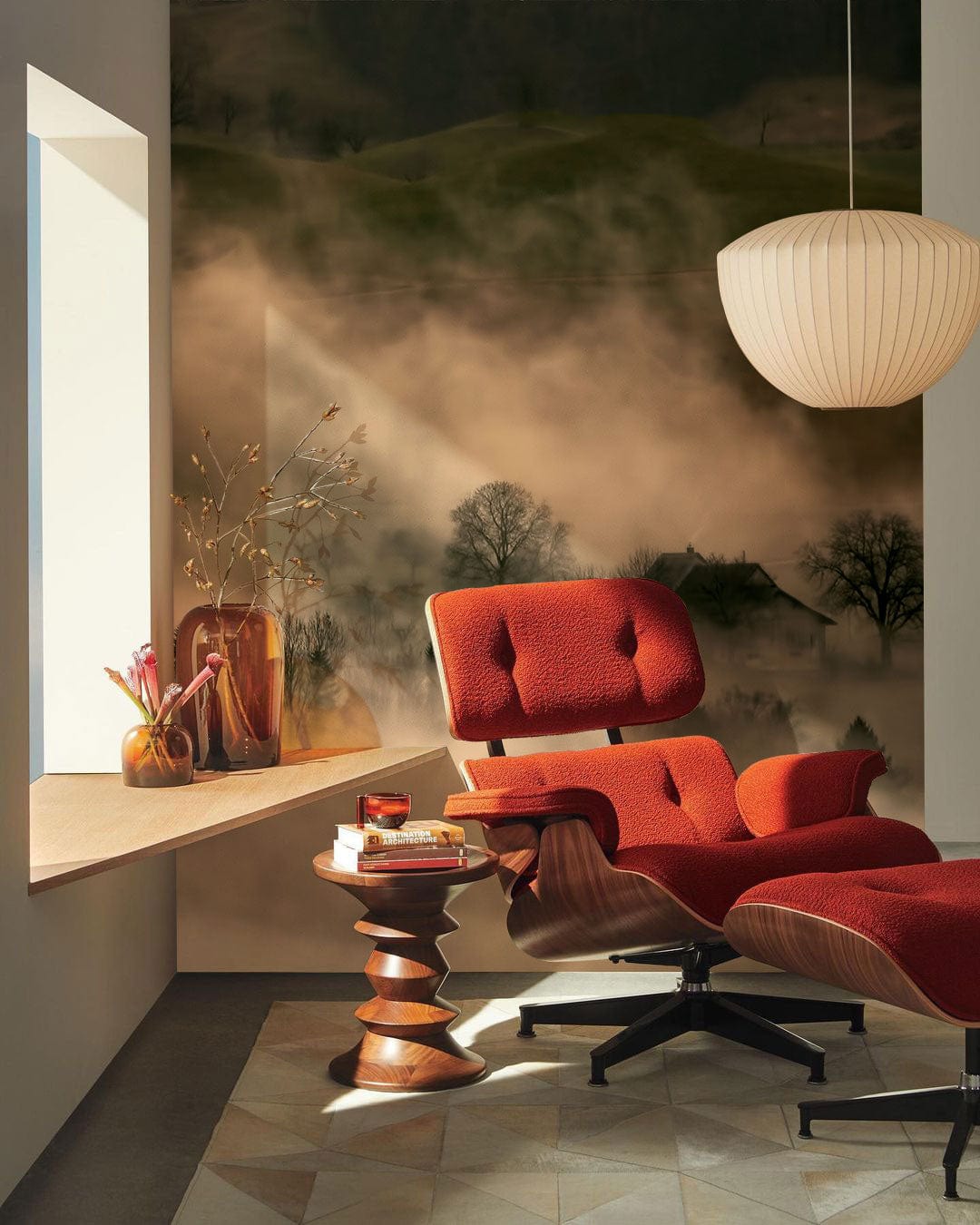 Tranquil Misty Woodland mural wallpaper, cosy red chair, modern pendant light, geometric rug, corner room.