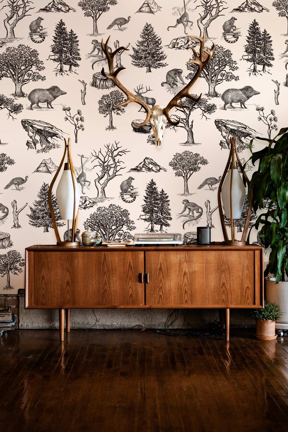 Vintage Sketch Wildlife Forest Wallpaper, wooden console, antler decor, hardwood flooring, nature-themed living room.