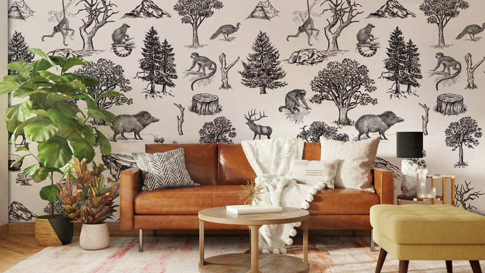 Vintage sketch wildlife wallpaper in living room with brown leather sofa, cream pillows, and wooden flooring.