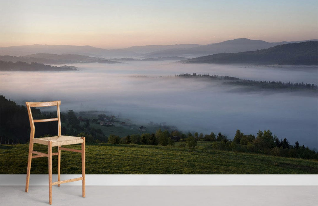 Tranquil Misty Morning Landscape Wallpaper in soft greens and blues with wooden chair, white skirting.