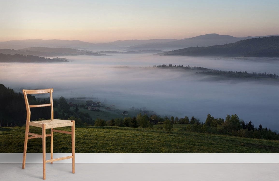 Tranquil Misty Morning Landscape Wallpaper in soft greens and blues with wooden chair, white skirting.