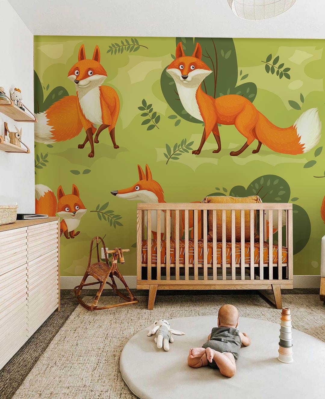 Nursery with Playful Foxes Forest Green Wallpaper, wooden crib, beige rug, modern dresser. Whimsical decor.