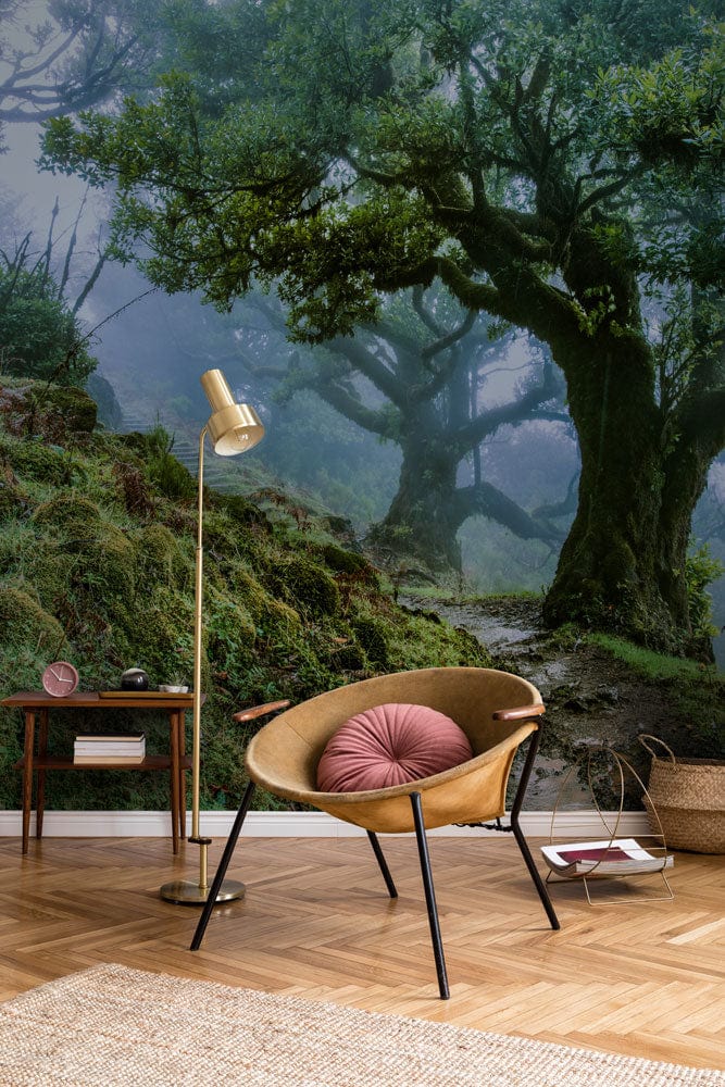 Mystical Forest Green Nature Mural Wallpaper in living room with wooden chair, lamp, parquet floor.