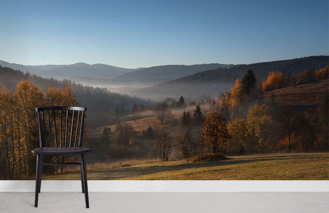 Autumn Misty Valley Landscape Mural Wallpaper with black chair, grey flooring, nature-themed decor in lounge.