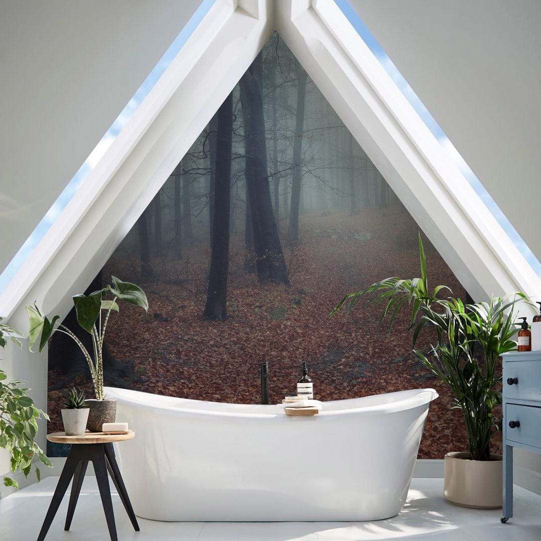 Misty Autumn Forest Mural Wallpaper in modern bathroom with freestanding white tub, triangular window.