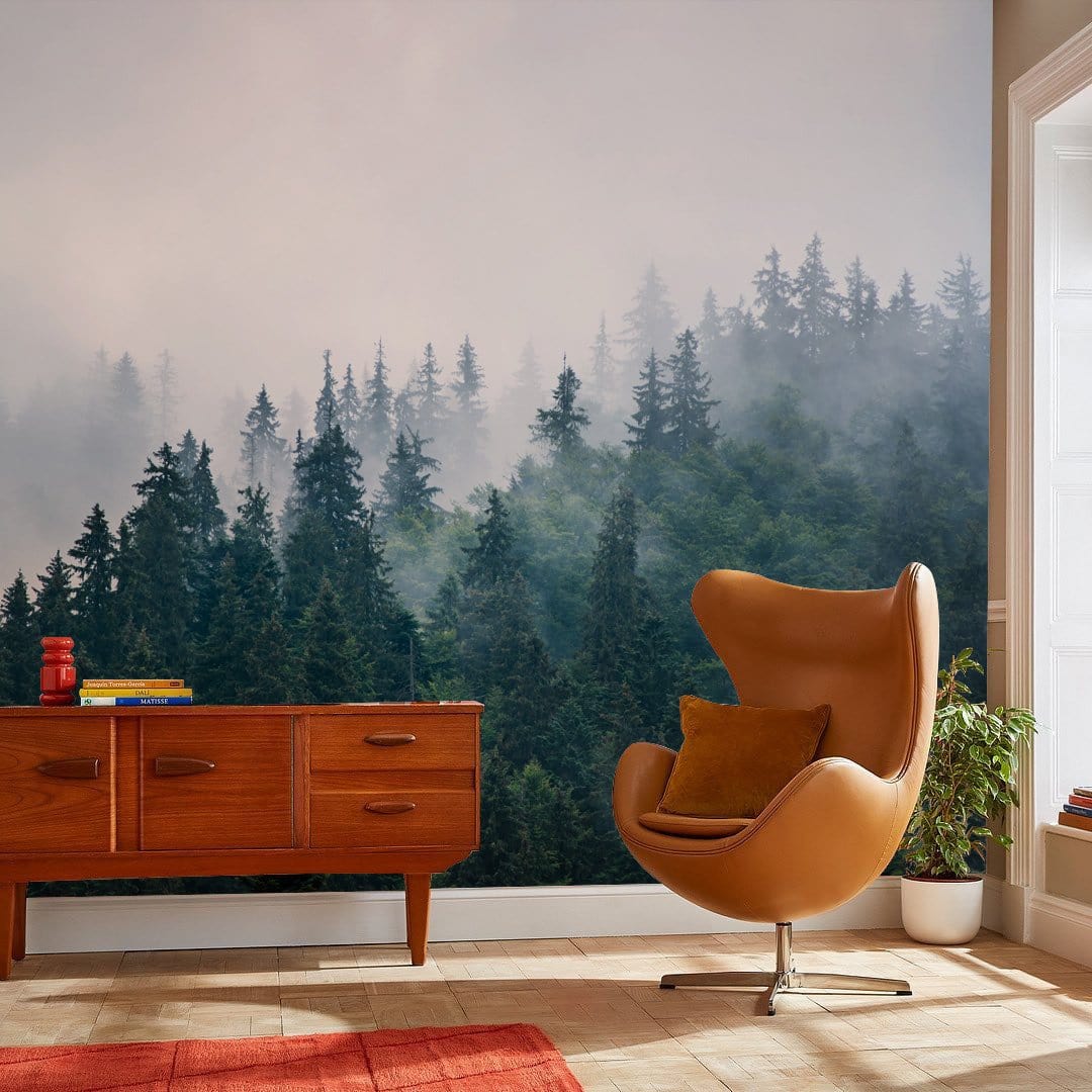 Misty Green Forest Mural Wallpaper in living room with a brown chair and wooden sideboard.
