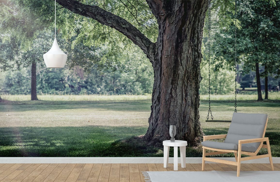 Serene Summer Parkland Mural Wallpaper with swing, sunlit trees, modern armchair, white table, pendant light.