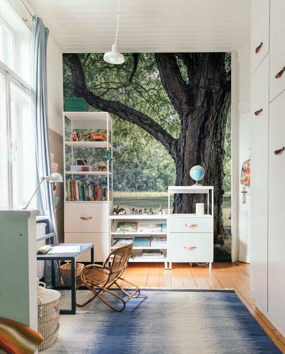 Serene Summer Parkland Mural Wallpaper, children's room, white cabinets, blue carpet, light wood flooring.