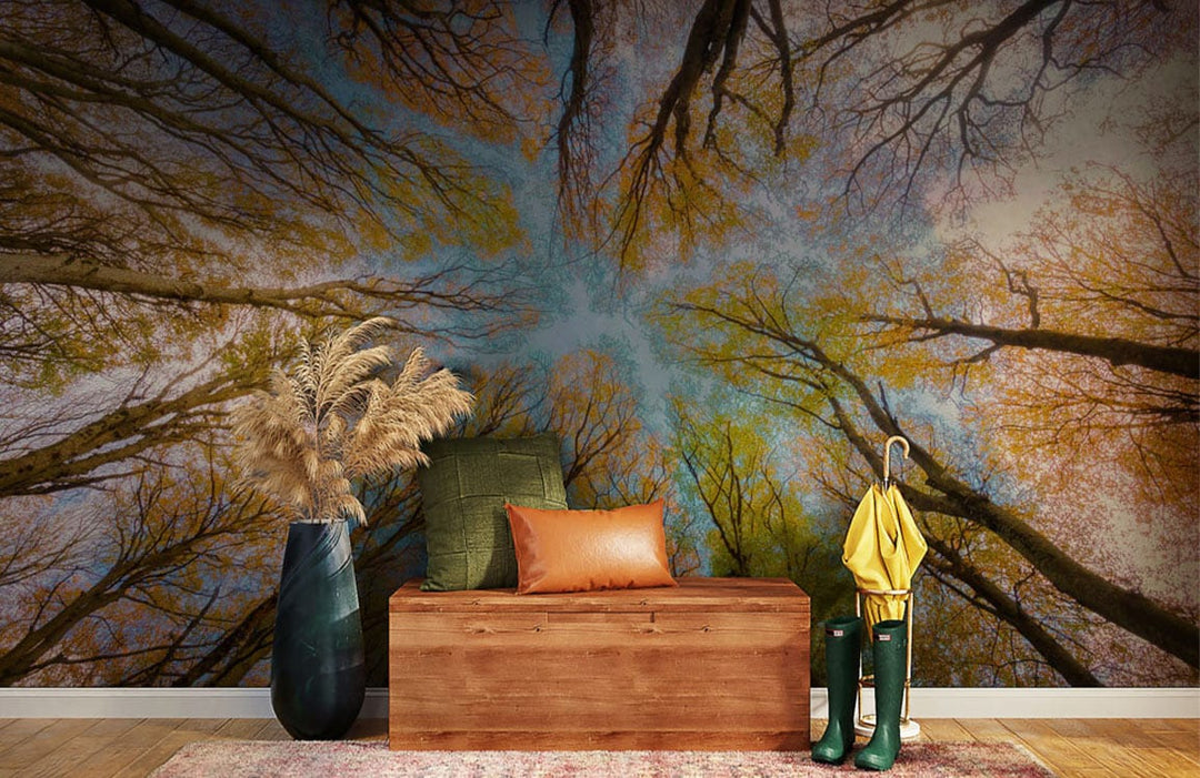 Autumn tree mural wallpaper in lounge with wood bench, leather cushions, blue vase, wooden flooring.