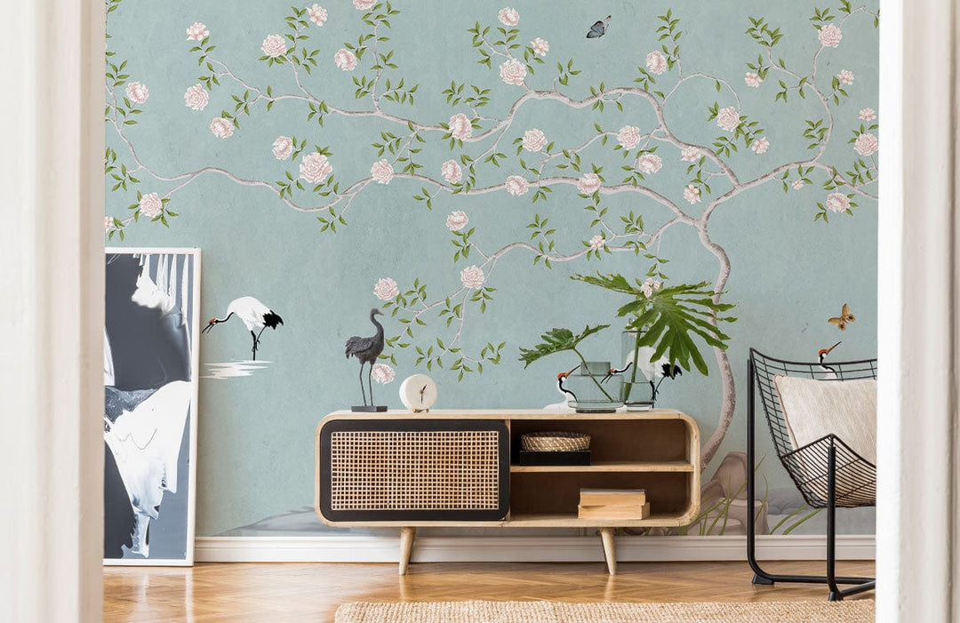 Serene Pastel Blue Crane Blossom Mural Wallpaper, woven sideboard, light wooden flooring, elegant decor.