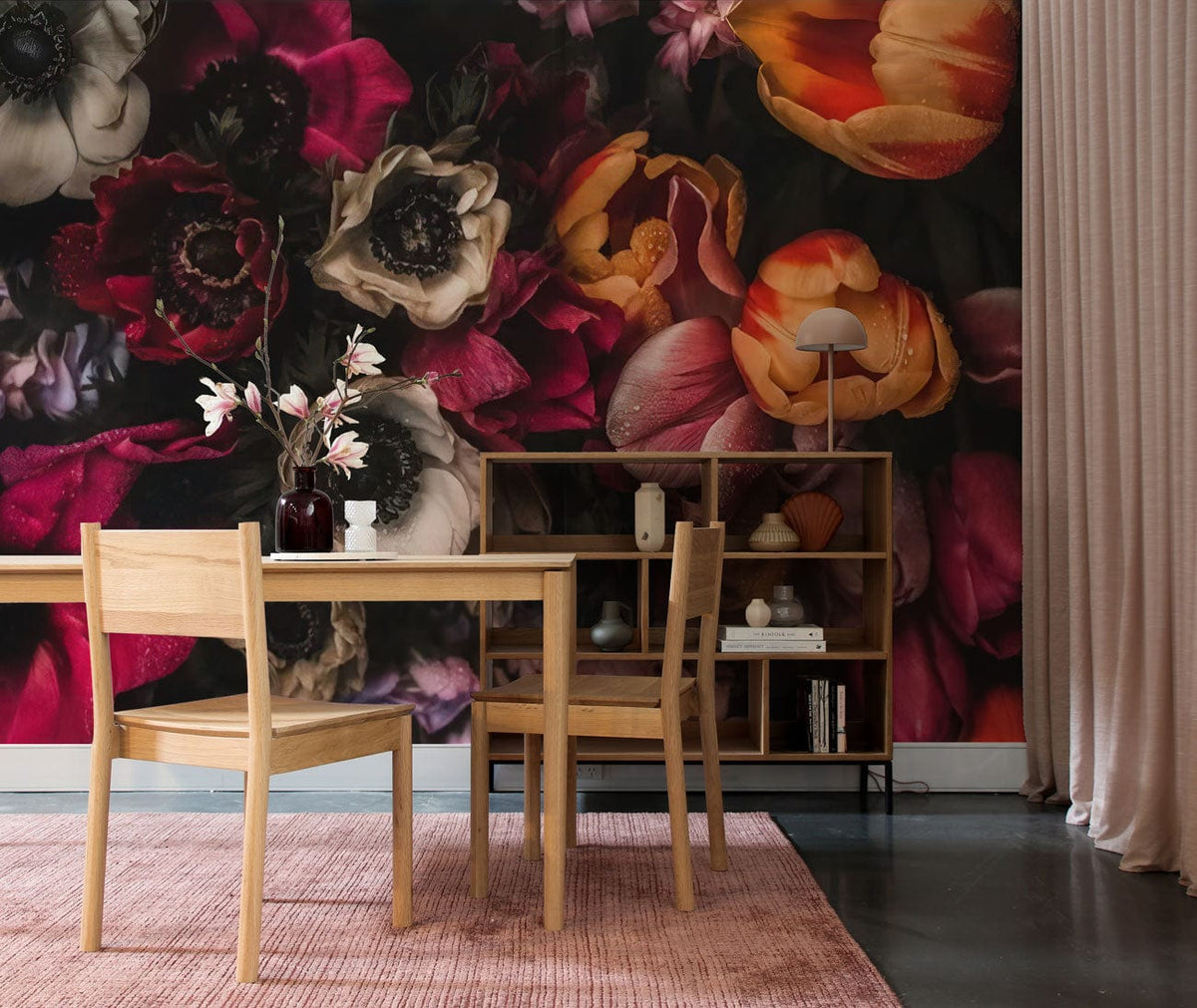 Elegant dark floral wallpaper with rich multicolour backdrop, wooden dining table, chairs, pink rug.