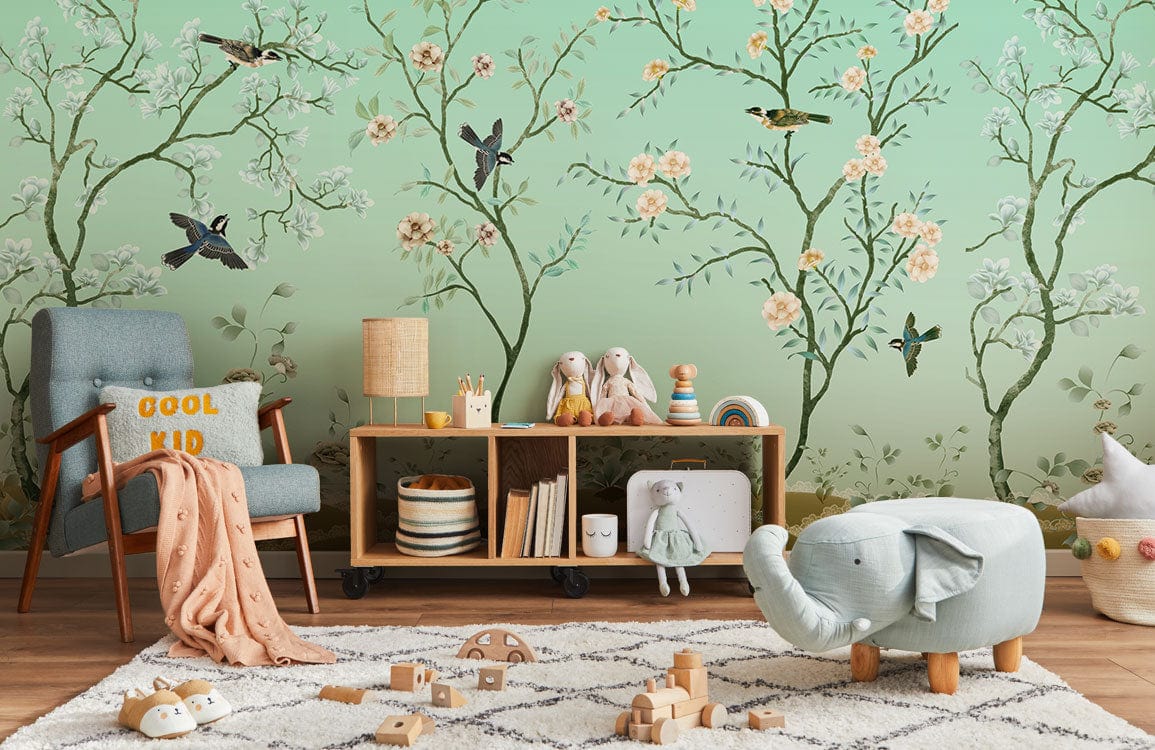 Mint green chinoiserie mural wallpaper, birds, floral design, children's room, blue armchair, white rug, toys.