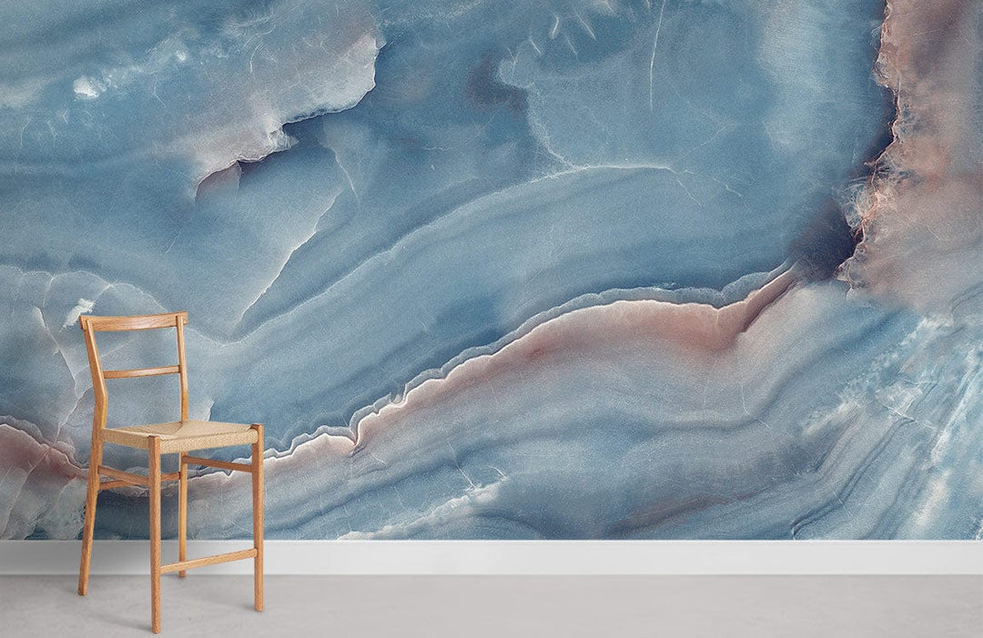 Elegant blue marble mural wallpaper with pastel hues, wooden chair, light flooring, modern room setting.