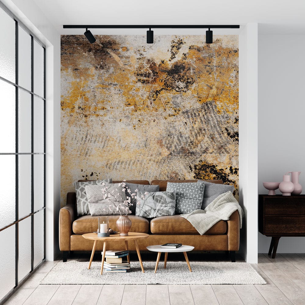 Rustic Industrial Ochre Charcoal Mural Wallpaper in living room with tan sofa, wooden table, large windows.