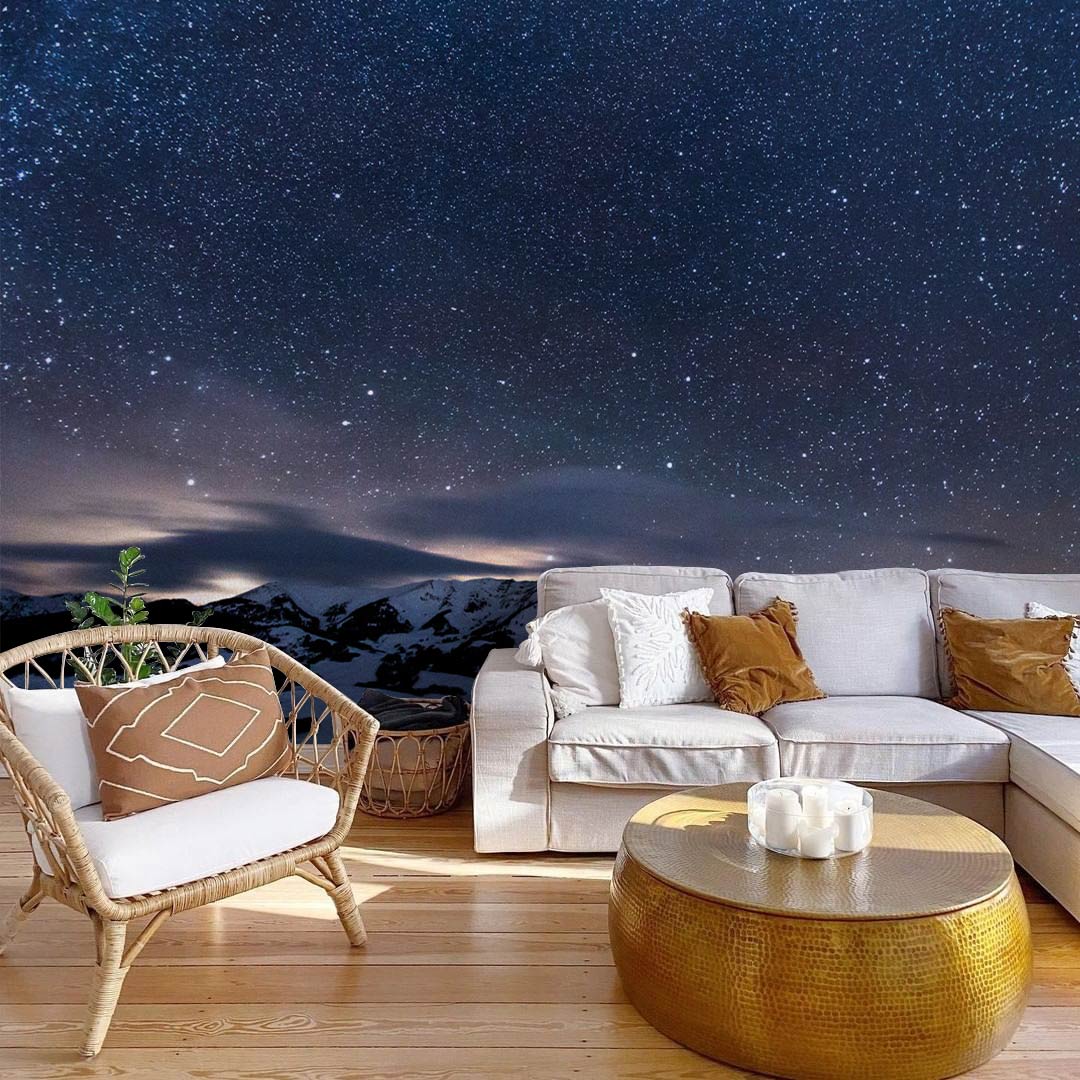 Starry Night Sky Mountain Mural adds serene elegance; features white sofa, woven chair, wooden flooring.