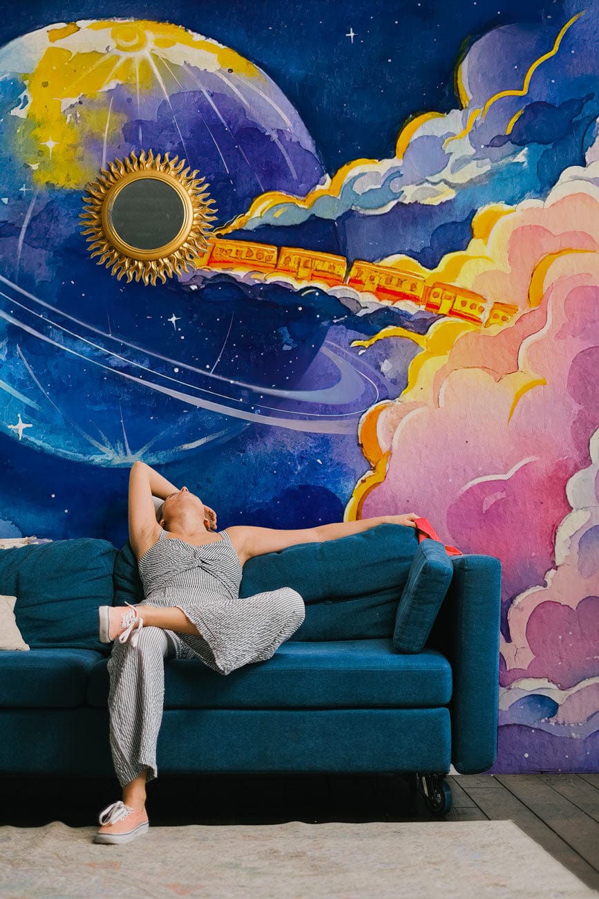 Celestial Train Journey mural wallpaper with blue sofa, wooden flooring, and celestial decor in living room.