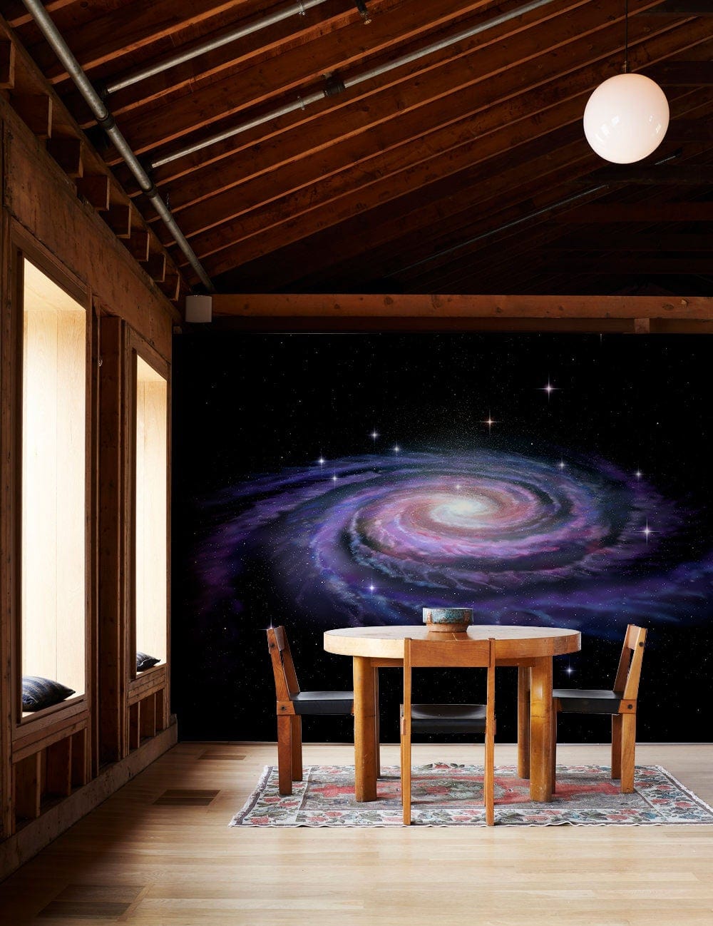 Dining room featuring Cosmic Spiral Mural Wallpaper, wooden table, hardwood flooring, rug, and ceiling lighting.
