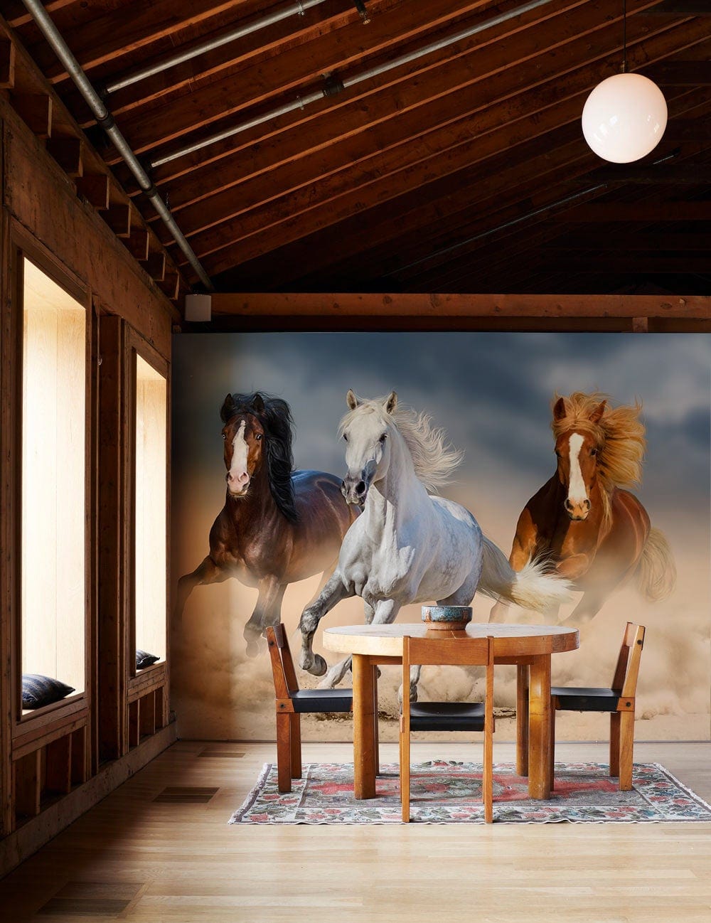 Galloping Horses Adventure Mural in wooden dining room with round table, colourful rug, and wooden flooring.