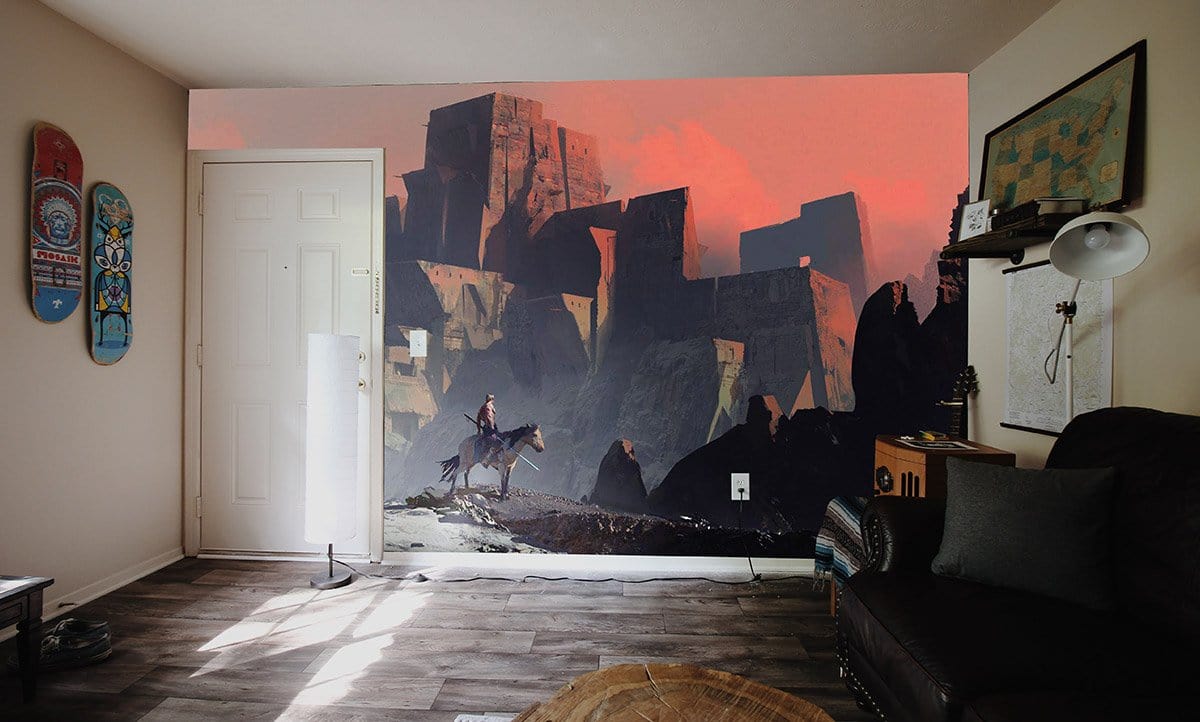 Mystical Sunset Fortress Mural Wallpaper in a cosy living room with dark sofa and wooden flooring.