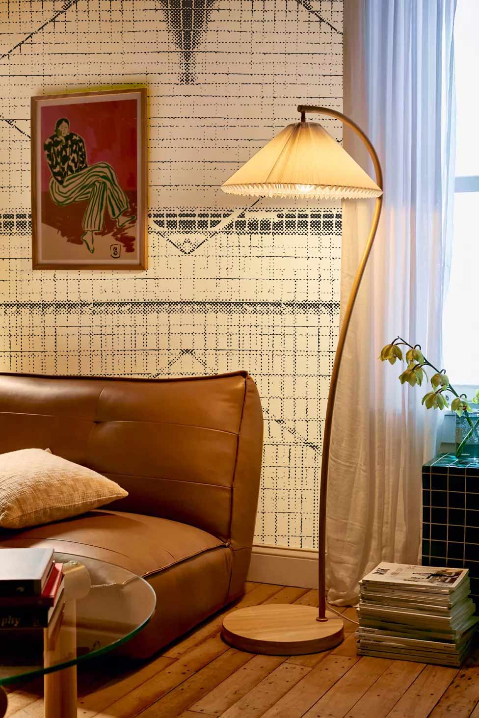 Geometric monochrome lines texture wallpaper in modern living room with brown leather sofa and wooden flooring.