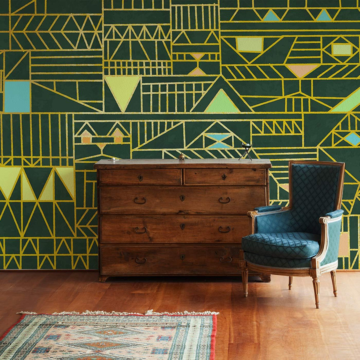 Geometric gold and teal Art Deco wallpaper, dark background, vintage dresser, blue chair, wooden floor.