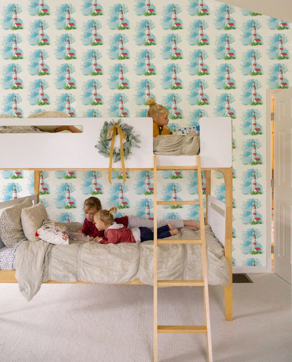 Whimsical Blue and White Seaside Pattern Wallpaper in children's room with wooden bunk bed, light flooring.
