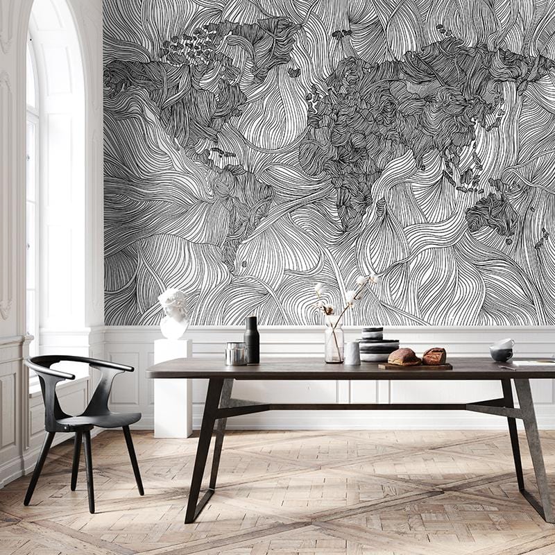 Monochrome world map mural wallpaper in dining room, featuring wooden table, chairs, and parquet flooring.