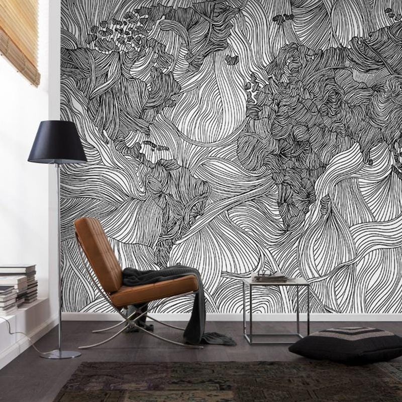 Monochrome map mural wallpaper with intricate patterns, brown armchair, black lamp, dark wood floor.